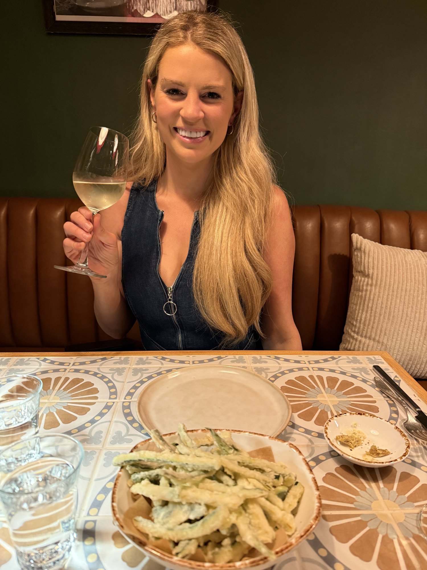 Savannah Sikes raising a glass of white wine at Bottega Salaria in Fredericksburg