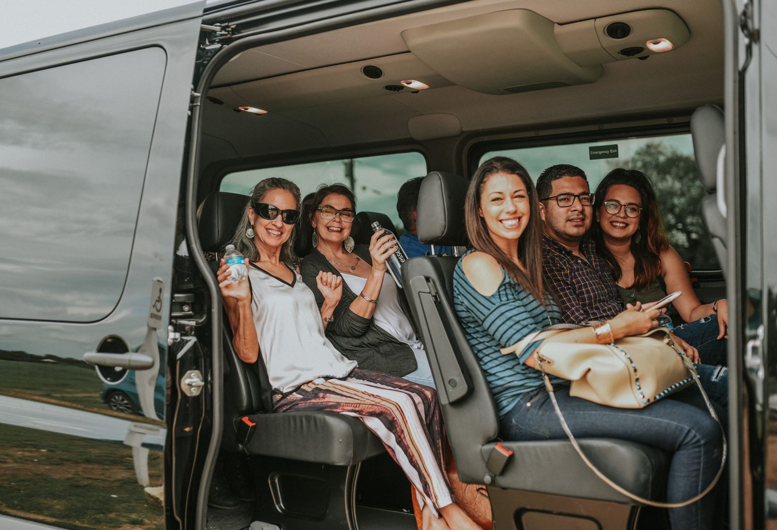 Guests relaxing in the leather seats of the Absolute Charm Sprinter van